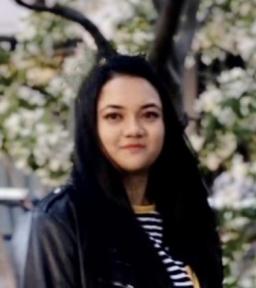 Headshot in black leather jacket and striped shirt in front of tree