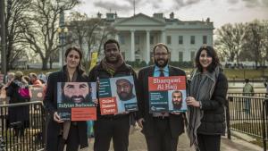 CCR Guantanamo team stands with photos of their clients in front of the White House