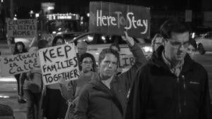 Protesters holding sign in support of family and sanctuaries