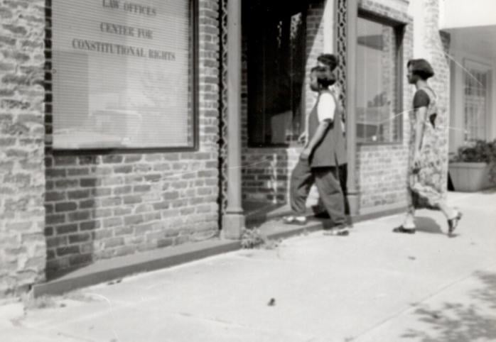 Three people are walking toward the front door of a law office.